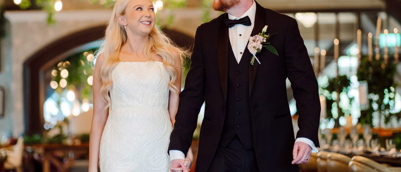 Bride and groom walking hand in hand in an elegant indoor setting at Rabbit Hotel & Retreat, showcasing modern wedding attire and a romantic atmosphere.